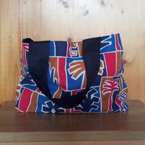 Knitting project bag made with a monkey/tree design, black even handles, inside beige with three pockets. Size 19*25*8 cm