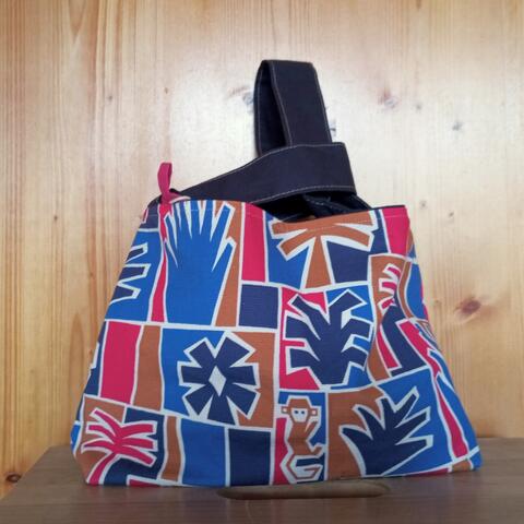 Knitting project bag made with a monkey/tree design, black uneven handles, inside beige with three pockets. Size 19*25*8 cm