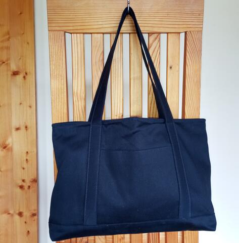 Dark blue tote bag with off white lining. One pocket on outside and four on inside of the bag. Medium long handles. Size: 25 x 35 x 13.5 cm.