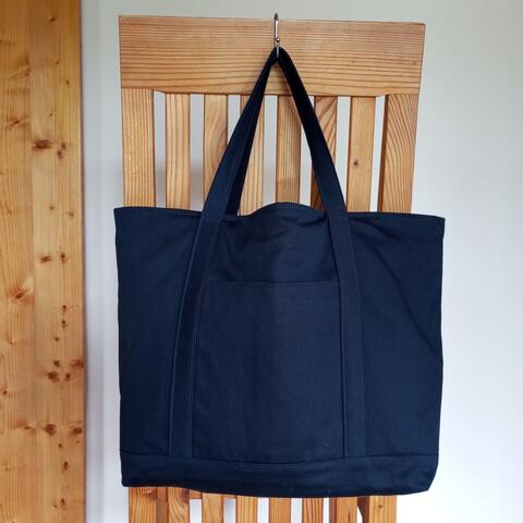 Dark blue tote bag with off white lining. One pocket on outside and four on inside of the bag. Short handles. Size: 32 x 33 x 15 cm.